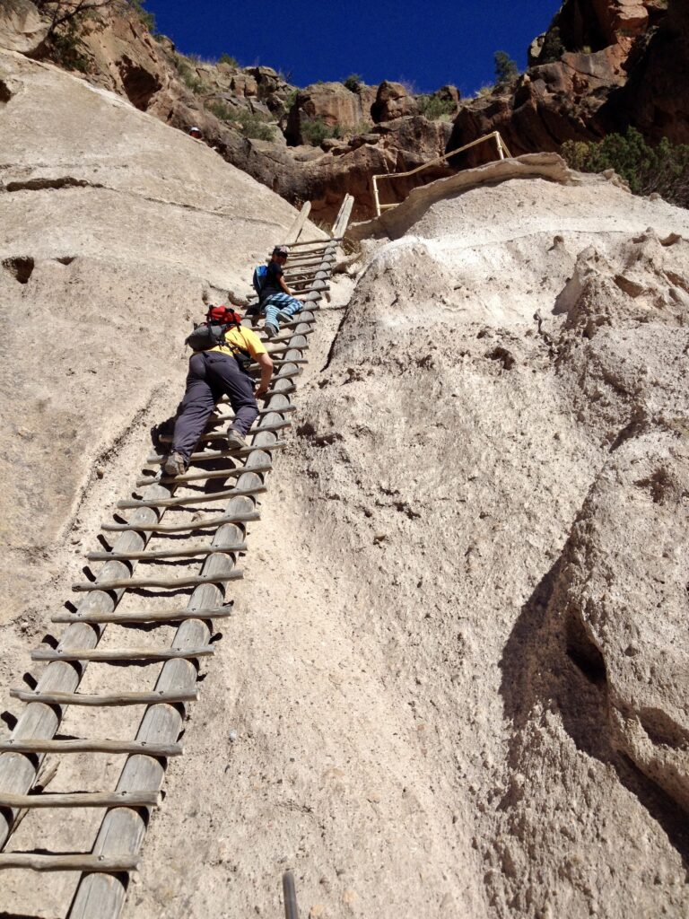 Climbing one of the four ladders up to the Alcove House in Bandelier National Monument.