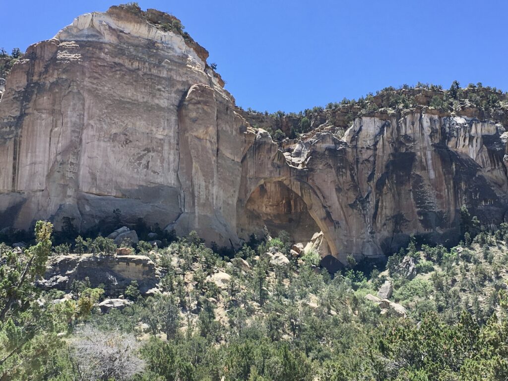 View of the sandstone bluffs with the arch in the middle in El Malpais National Monument, New Mexico.