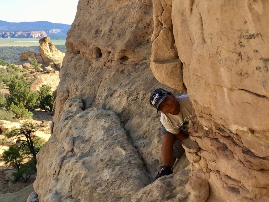 Scrambling amongst the rocks of the sandstone cliffs in El Maipais National Monument, New Mexico.
